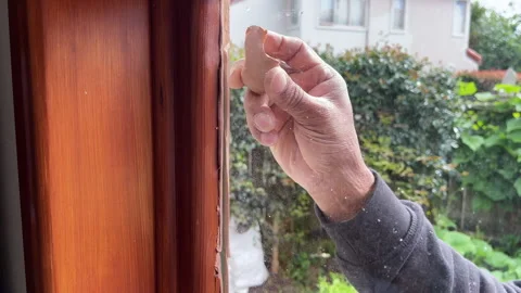 Close-up of a glazier's hand rolling putty on a newly installed pane of glass Stock Footage 281703942
