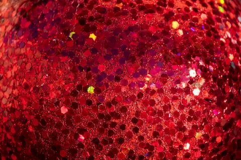 A close-up of a glittering red surface, featuring hexagonal reflective part.. Stock Photos
