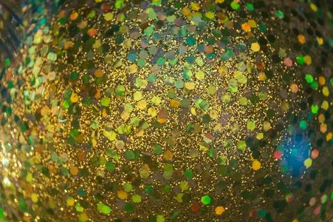A close-up of a glittering yellow surface, featuring hexagonal reflective p.. Stock Photos