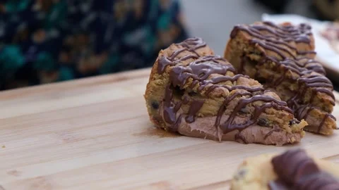 Close up of gloved hand lifting chocolate mousse filled cake slice with drizzle Video stock 327424286