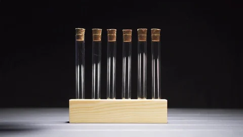 Close-up of a gloved hand pulls a test tube from the stand. 스톡 동영상 121925707