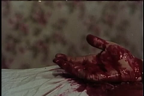 Close-up of gloved hand putting crucifix in bloody hand 스톡 동영상 11354532