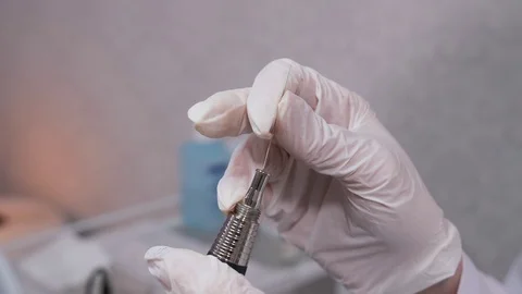Close-up, gloved hands insert a needle into a machine for permanent makeup. 4K Stock-Footage 106892312