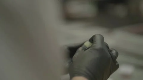 Close-up of gloved hands kneading yellow ball Vídeos de archivo 336374753