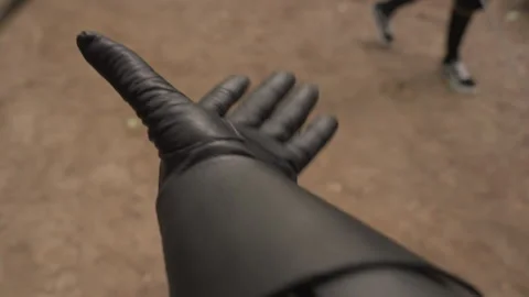 Close up gloved hands manipulating sword in sequence on dirt ground with another Stock Footage 345083470