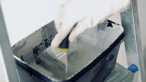 Close-up of gloved hands mixing grey paint or plaster with a spatula Stock Footage 114103785
