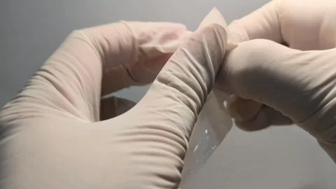 Close Up of Gloved Hands Opening Sterile Medical Swab Pack Video stock 339646773