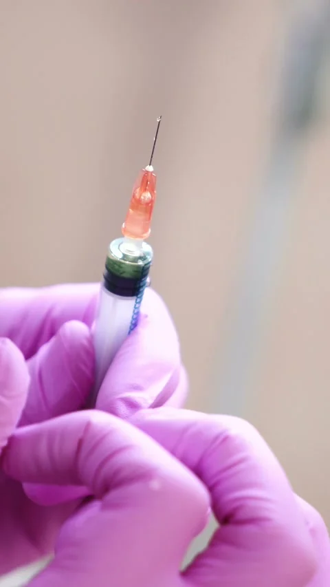 Close up of gloved hands preparing syringe with needle for injection. Stock Footage 337634884