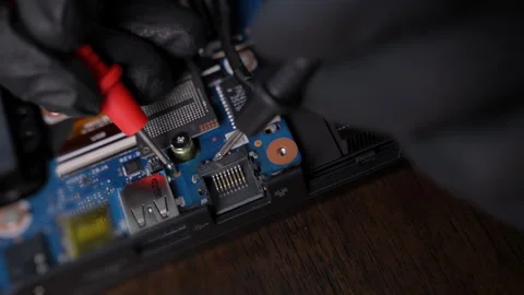 Close-up of gloved hands using multimeter probes to test an electronic Stock Footage 326085702