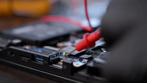 Close-up of gloved hands using multimeter probes to test an electronic Stock Footage 326086127