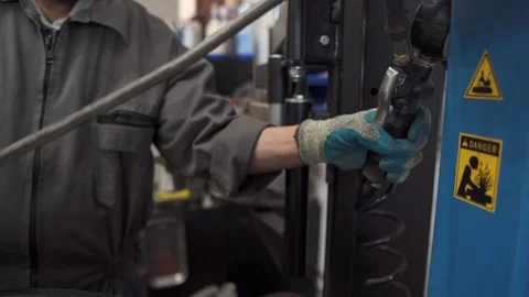 CLOSE UP OF GLOVED WORKER OPERATING PNEUMATIC HAND CONTROL IN AUTOMOTIVE Stock Footage 346514699