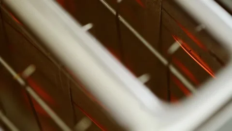 Close up glowing heating elements inside white toaster in warm kitchen lighti Stock Footage 334570243