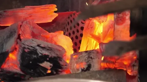 Close-up of glowing hot charcoal and vibrant flames in a barbecue grill, ready f Stock Footage 338210797