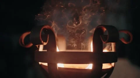 Close-up of a glowing iron brazier with swirling smoke and bright flames, Stock Footage 283063971