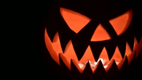 Close up of glowing jack-o-lantern lit from inside with candles Stock Footage 313081832