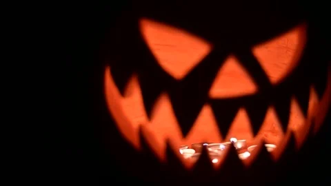 Close up of glowing jack-o-lantern lit from inside Stock Footage 317311729