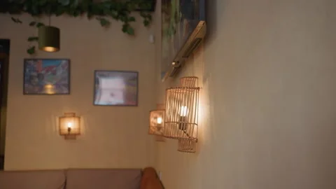 Close up of glowing light bulb in decorative wall frame inside cozy interior Stock Footage 310761092