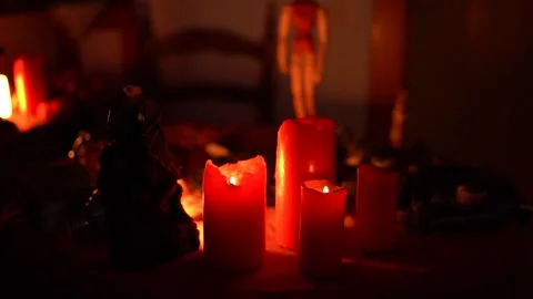 Close-up of glowing red candles with soft flames, dramatic low-light scene Video stock 326878177