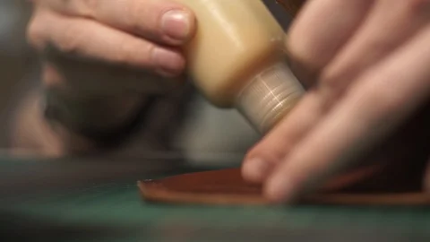 Close-up of glue application on the workpiece. Handwork. A tanner in a workshop Stock Footage 104927757