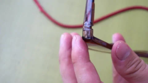 Close-up gluing some glasses and pressing to fix them Stock Footage 149386061