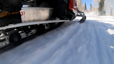 Close up go pro shot of snowmobile wheels and track driving on the snowy road. Stock Footage 108940586