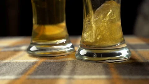 Close-up of goblets with pouring beer on black background 4k Stock Footage 129255567