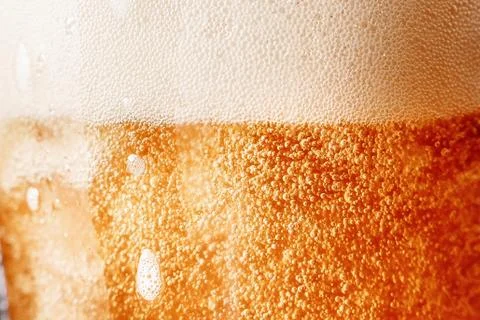 Close up gold background texture of yellow lager beer with froth and bubbles in Stock Photos