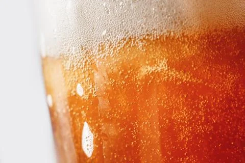 Close up gold background texture of yellow lager beer with froth and bubbles in 스톡 사진