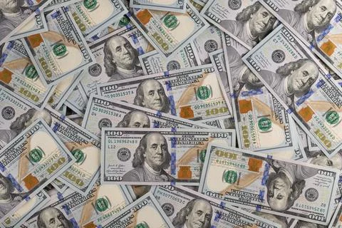 Close Up Gold Bar Shaped Like US One Hundred Dollar Bill on Scattered Cash .. Stock Photos