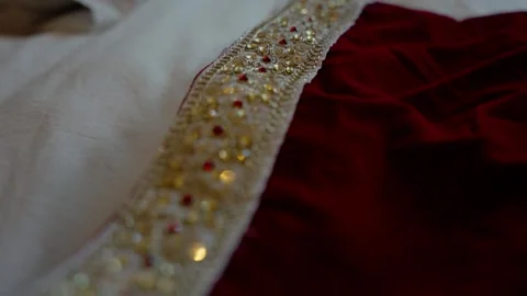 Close up of gold beaded trim on red velvet wedding fabric Stock Footage 342395703