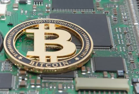 Close-up of gold bit coin, computer circuit board with bitcoin processor and  写真素材