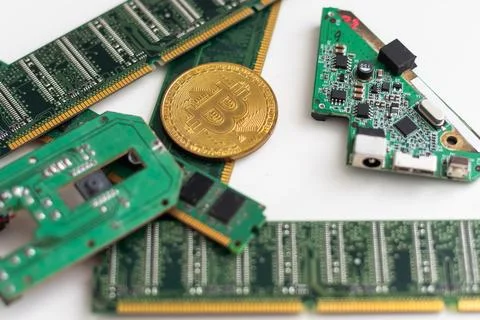 Close-up of gold bitcoin on computer components background, technology and Stock Photos
