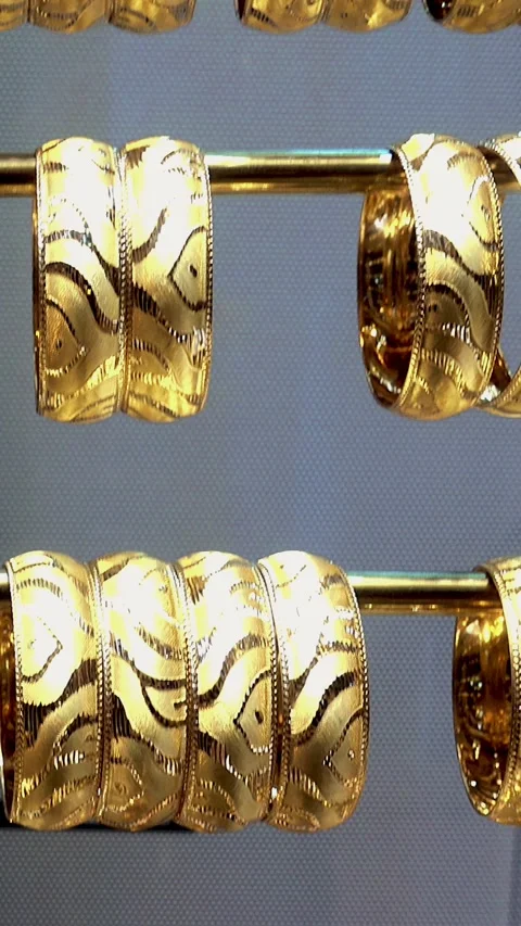 Close-up of gold bracelets arranged on horizontal rods 스톡 동영상 337061767