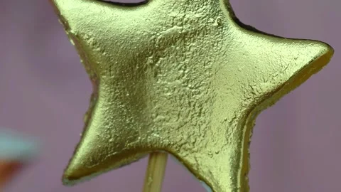 Close up of gold star shaped cake decor. Candy star, macro view. Video stock 301605458