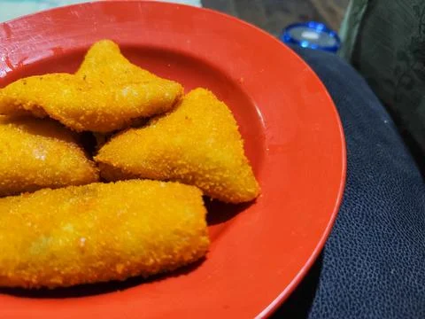 Close Up of Golden Breaded Fried Snacks on Red Plate with Crispy Texture 스톡 사진