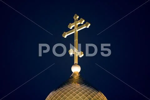 Close-up of golden dome of orthodox church with big cross at night Stock Photos