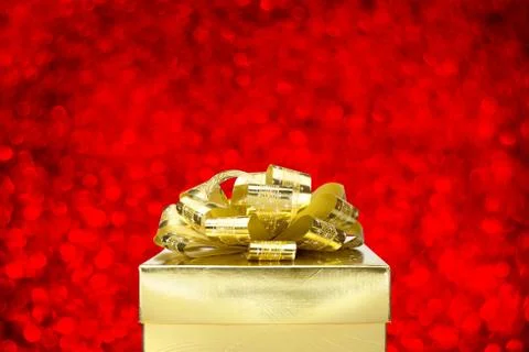 Close up Golden present box with big bow at bokeh white blur background, Leav Stock Photos