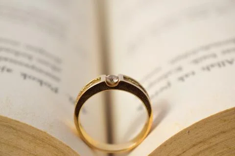 Close up golden ring with diamond between book opened Stock Photos