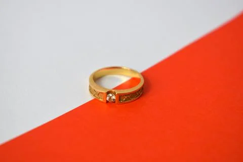 Close Up Golden ring with diamond on diagonal white and orange background Stock Photos
