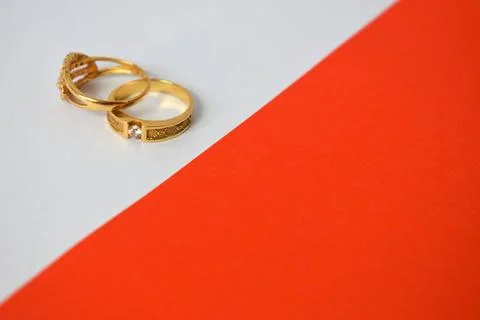 Close Up Golden ring with diamond on diagonal white and orange background Stock Photos