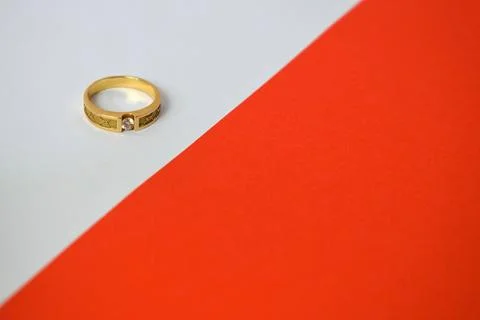 Close Up Golden ring with diamond on diagonal white and orange background 스톡 사진