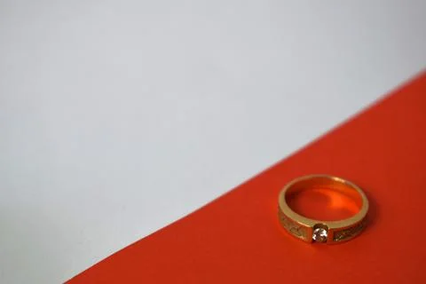 Close Up Golden ring with diamond on diagonal white and orange background Foto stock