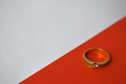 Close Up Golden ring with diamond on diagonal white and orange background Stock Photos