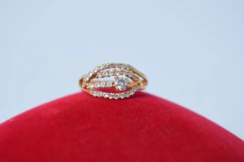 Close Up Golden ring with diamond on red carpet texture Background Stock-Fotos