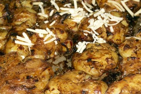 Close Up Of Golden Roasted Smashed or Crushed Potatoes on a Baking Tray Stock Photos