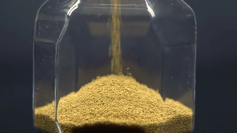 Close-up of golden sand falling inside an hourglass creating a slide. Stock Footage 172344185