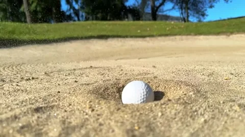 Close Up on a Golf Ball Falling in the Sand Trap in a Sunny Day 動画素材 265058400