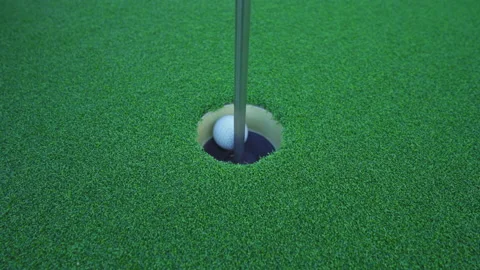 Close up golf ball in hole on grass in golf club, simulation court sport equi Stock Footage 152956609