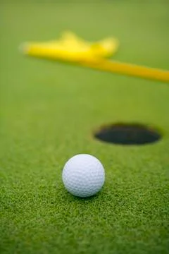 Close-up of golf ball by hole Stock Photos
