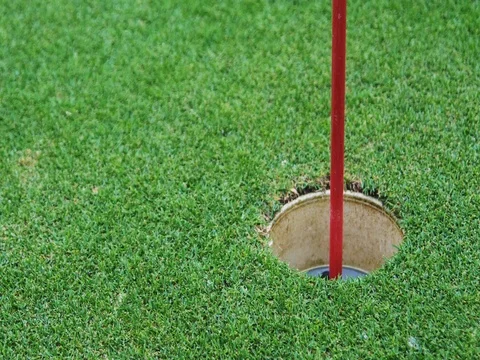 Close up of a golf ball rolling into a hole. Stock Footage 69774426